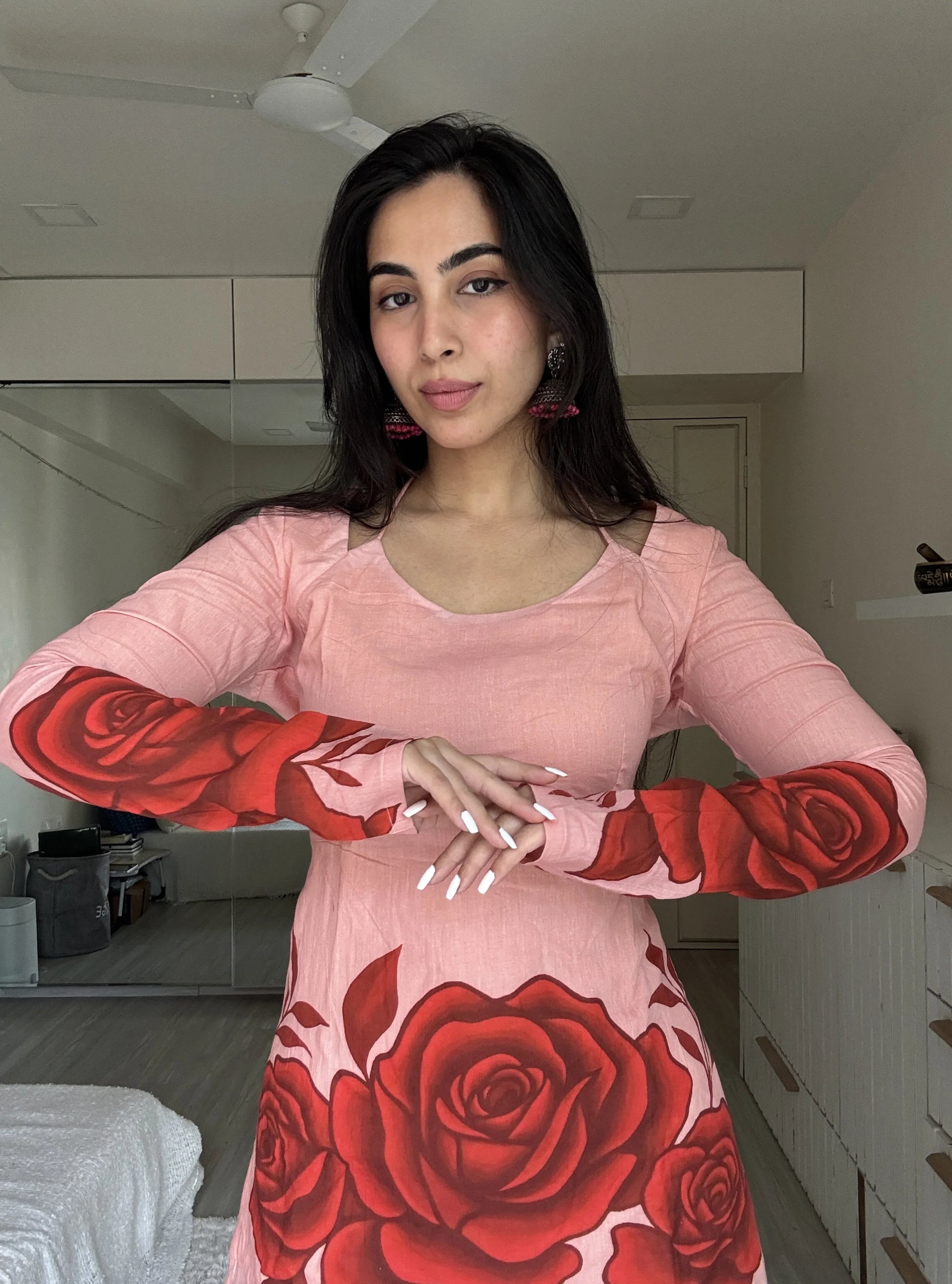 “Woman wearing blush pink kurti with bold red rose print sleeves and hem – Heer front view”