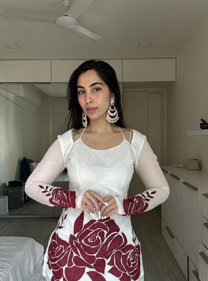 “Close‑up of red rose artwork on sleeves of Surbhi off‑white kurti”