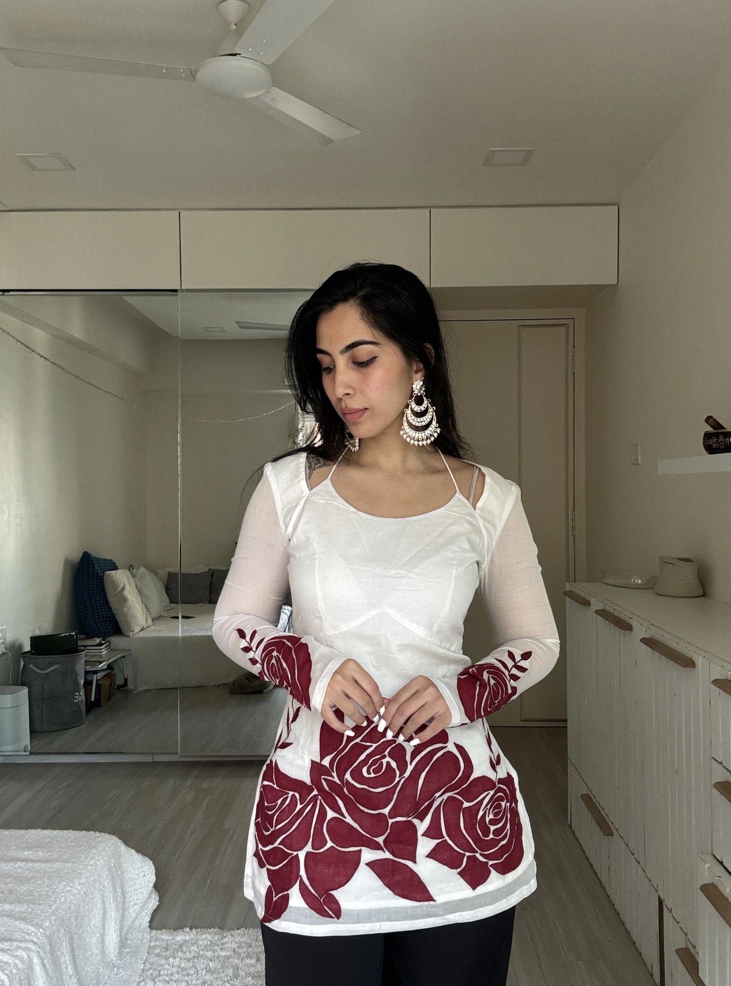 “Woman wearing off‑white kurti with red rose print sleeves and hem – Surbhi front view”