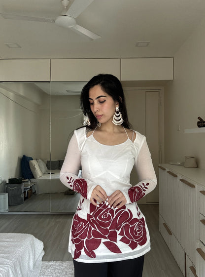 “Woman wearing off‑white kurti with red rose print sleeves and hem – Surbhi front view”